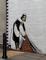 Sweeping maid stencil graffiti by Banksy